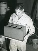 Al Litvin holding the all-clay construction block developed at Armour Research Foundation, Illinois Institute of Technology, Chicago, Illinois, ca. 1956