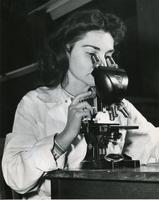 Trudy Cheskis using microscope, Illinois Institute of Technology, Chicago, Illinois, 1947